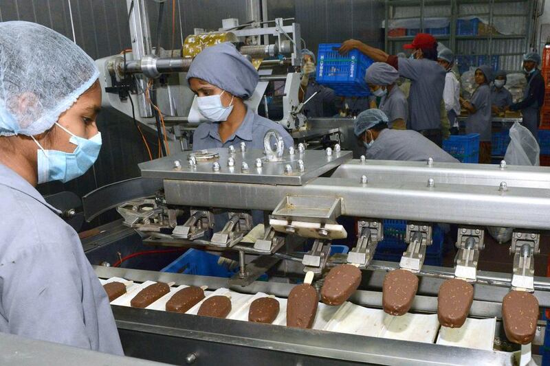 Indian factory workers monitor a production line at the Havmor Ice Cream Limited plant at Naroda near Ahmedabad. Havmor produces some 200,000 litres of ice cream daily from its two factories during the peak summer season when demand for their products are high. Sam Panthaky / AFP