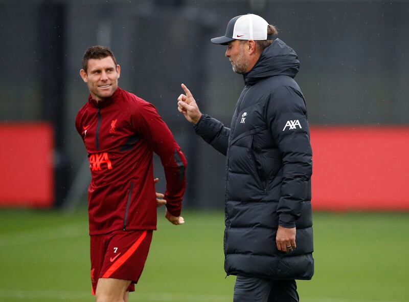 Liverpool manager Juergen Klopp talks to James Milner. Reuters
