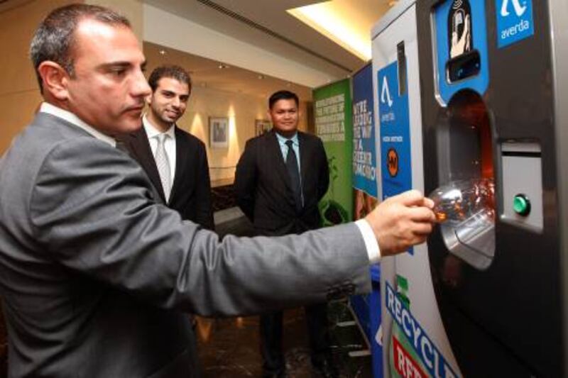 Dubai, 28th September 2011.  Wadih Shamma (General Manager Levant of RMS Outdoor) tries a pet bottle during the presentation of Reverse Vending Machine for recyclable empty pet bottles, glass bottles and cans.  (Jeffrey E Biteng / The National)