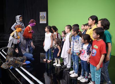 Afghan puppeteers Seema Sultani (L) and Mansoora Shirzad hold Sesame Street Muppets 'Zeerak' and 'Zari' as they meet children after a recording at a television studio in Kabul. Wakil Koshar / AFP