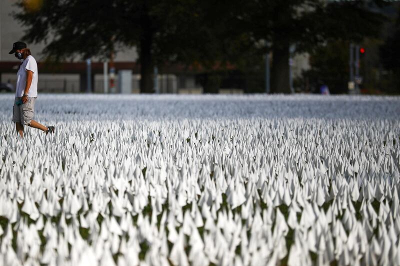 A person walks past the art installation "In America How Could This Happen" by artist Suzanne Brennan Firstenberg, at the DC Armory Parade Ground, in Washington as the coronavirus disease  continues to spread. Reuters