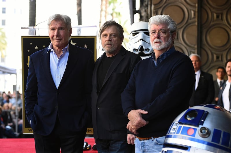 Mark Hamill, centre, poses with fellow 'Star Wars' cast member Harrison Ford, left, and creator George Lucas as Hamill is honored with a star on the Hollywood Walk of Fame. Jordan Strauss / Invision / AP