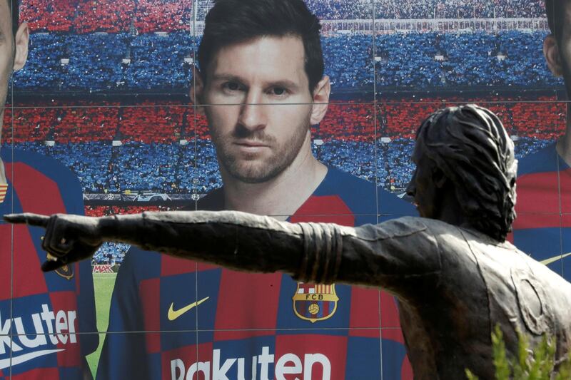 Soccer Football - Camp Nou, Barcelona, Spain - August 26, 2020   A statue of Johan Cruyff is seen infront of an image of Lionel Messi outside the Camp Nou after captain Lionel Messi told Barcelona he wishes to leave the club immediately, a source confirmed on Tuesday   REUTERS/Nacho Doce