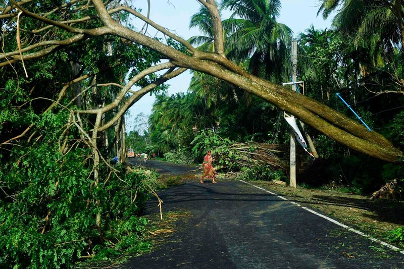 A woman removes debris from a road after the landfall of cyclone Amphan in Midnapore, West Bengal.  AFP