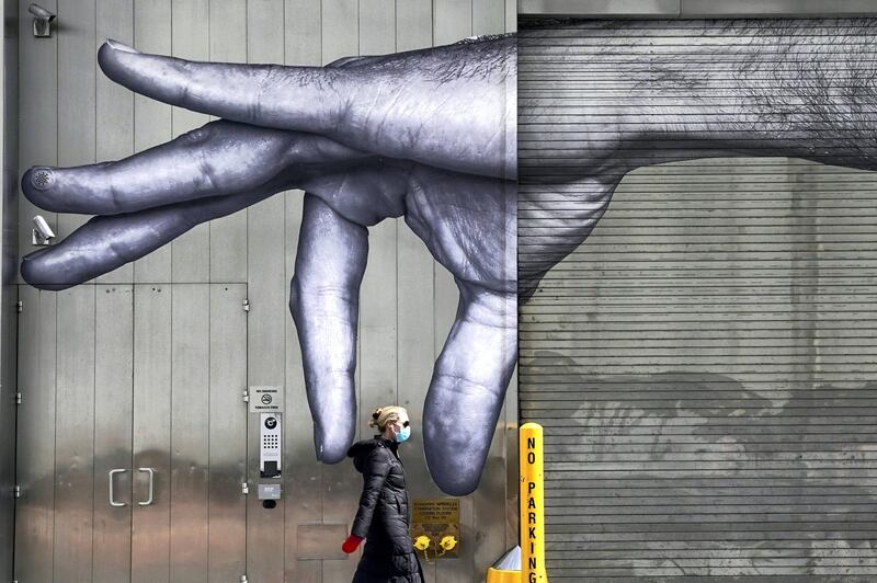 -- AFP PICTURES OF THE YEAR 2020 --

A woman in a mask walks past a mural of a hand on the side of a building in Midtown New York City  April 22, 2020. - Governor Andrew M. Cuomo said he would extend New York State’s shutdown until May 15 in coordination with other states to make progress in containing the coronavirus. (Photo by TIMOTHY A. CLARY / AFP)