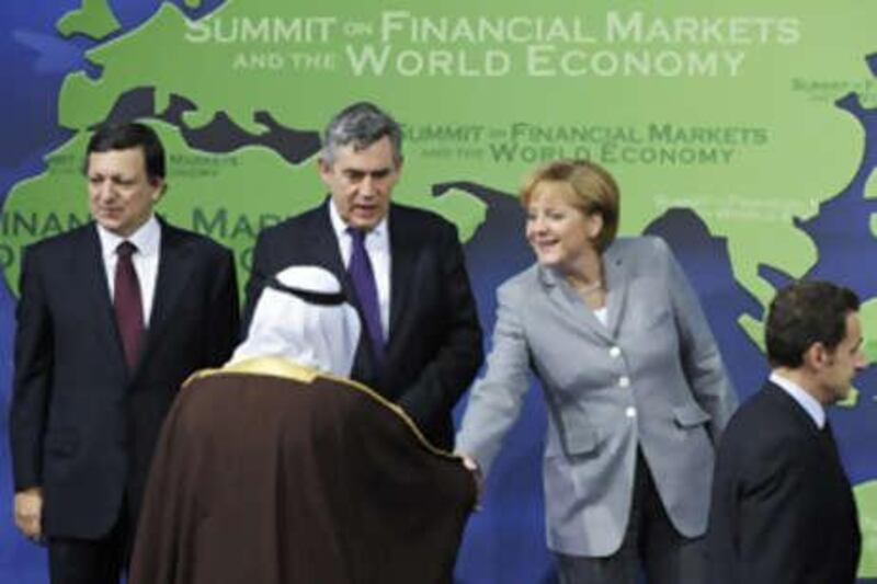 The German Chancellor Angela Merkel shakes hands with the Saudi King Abdullah Al Saud as they take their places for the family photo next to the EU Commission President Jose Manuel Barroso, left, and the British Prime Minister Gordon Brown and the French President Nicolas Sarkozy at the opening of the G20 Summit on Nov 15, 2008 in Washington, DC.