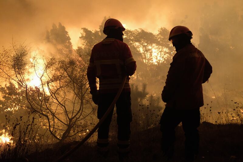 Firefighters work to extinguish a fire in Lugar de Sao Tome, Valenca, North of Portugal. Armenio Belo / EPA