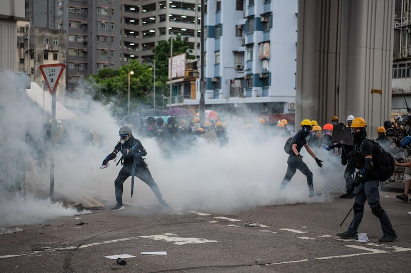 HONG KONG, CHINA - JULY 27: A protester pours liquid onto a tear gas canister during a demonstration in the district of Yuen Long on July 27, 2019 in Hong Kong, China. Pro-democracy protesters have continued weekly rallies on the streets of Hong Kong against a controversial extradition bill since 9 June as the city plunged into crisis after waves of demonstrations and several violent clashes. Hong Kong's Chief Executive Carrie Lam apologized for introducing the bill and recently declared it "dead", however protesters have continued to draw large crowds with demands for Lam's resignation and completely withdraw the bill. (Photo by Laurel Chor/Getty Images)