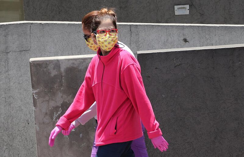 Women wear face masks and gloves as a precaution against the spread of the coronavirus, in Quito, Ecuador. AP Photo