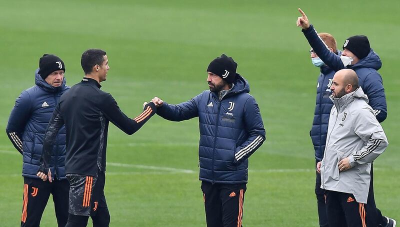 Juventus manager Andrea Pirlo, centre, greets Cristiano Ronaldo during the team's training. EPA