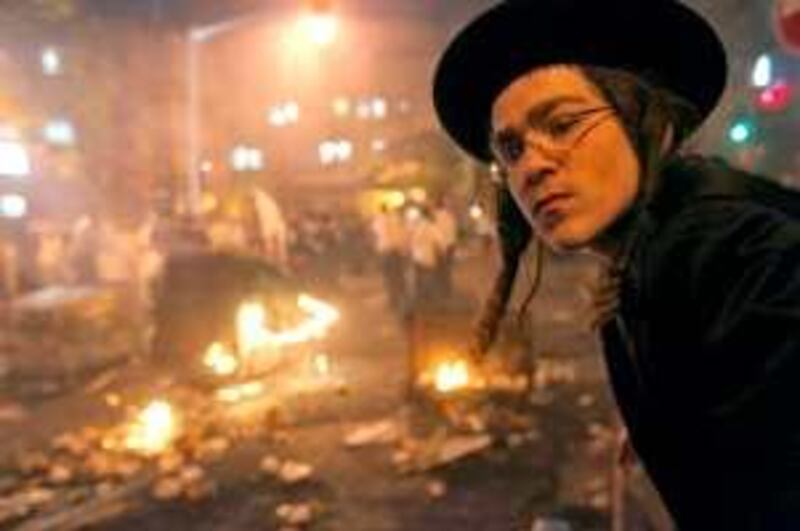 An Ultra Orthodox Jew looks at the main road of their Ultra Orthodox neighbourhood of Mea Sharim blocked with burning garbage container during a demonstration in Jerusalem on June 6, 2009. Thousands of Orthodox Jews clashed with Israeli police in Jerusalem in protest over the inauguration of a municipal parking lot, the Jewish sabbath.    AFP PHOTO/ MENAHEN KAHANA