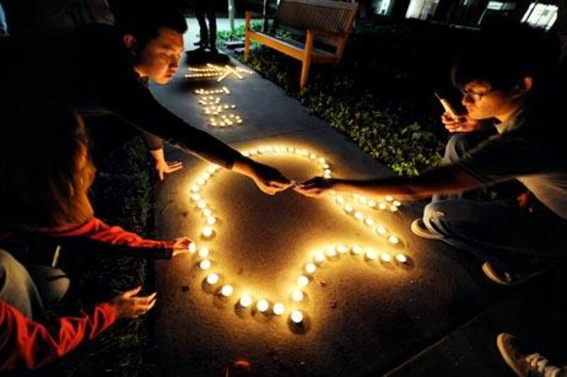 CUPERTINO, CA - OCTOBER 05: Chinese exchange students from nearby De Anza College use candles to create the Apple logo and Steve Jobs' last name in Chinese characters at a makeshift memorial for Steve Jobs at the Apple headquarters on October 5, 2011 in Cupertino, California. Jobs, 56, passed away after a long battle with pancreatic cancer. Jobs co-founded Apple in 1976 and is credited, along with Steve Wozniak, with marketing the world's first personal computer in addition to the popular iPod, iPhone and iPad.   Kevork Djansezian/Getty Images/AFP== FOR NEWSPAPERS, INTERNET, TELCOS & TELEVISION USE ONLY ==

