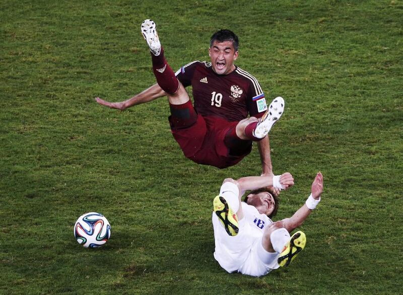 South Korea’s Ki Sung-yueng (bottom) fouls Russia’s Alexander Samedov during their 2014 World Cup Group H football match at the Pantanal arena in Cuiaba. David Gray / Reuters