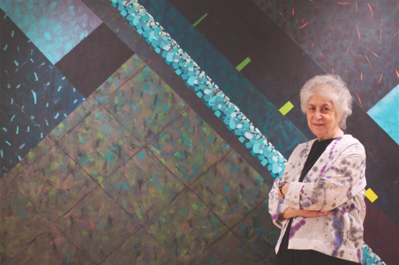 Samia Halaby stands next to her painting, Night Seeing.