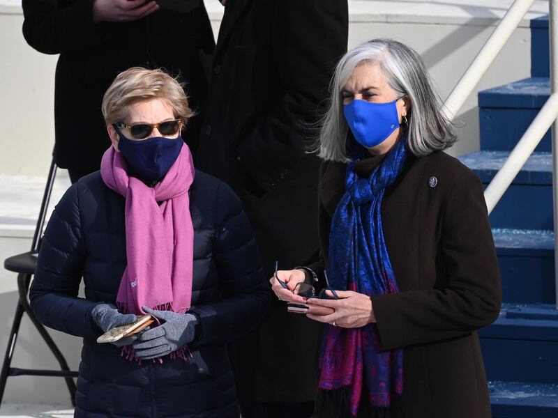 Senator Elizabeth Warren, left, wears a pink-purple scarf as she arrives for the presidential inauguration. AFP