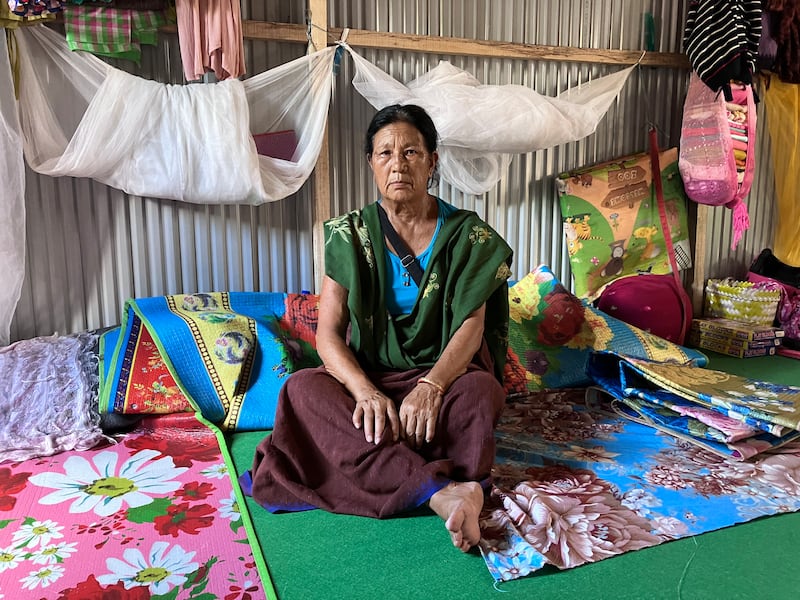 A Meitei woman sitting in a room that she shares with five families at a relief camp