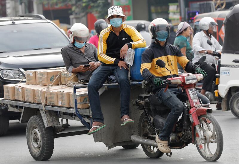 People ride a motorised cart travelling on a street in Phnom Penh, Cambodia. EPA