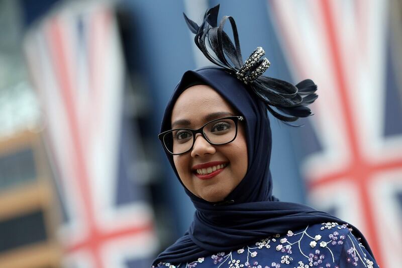 A racegoer poses for a photograph on day one of the Royal Ascot horse racing meet, in Ascot, west of London, on June 19, 2018.  The five-day meeting is one of the highlights of the horse racing calendar. Horse racing has been held at the famous Berkshire course since 1711 and tradition is a hallmark of the meeting. Top hats and tails remain compulsory in parts of the course while a daily procession of horse-drawn carriages brings the Queen to the course.  / AFP / Daniel LEAL-OLIVAS
