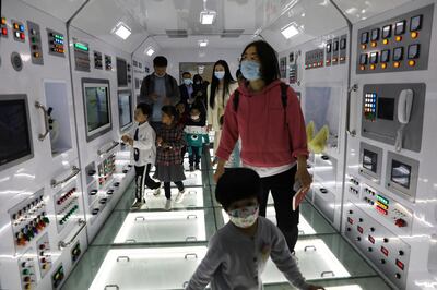 Visitors walk inside a model of the core module of the Tianhe space station at an exhibition featuring the development of China's space exploration on the country's Space Day at China Science and Technology Museum in Beijing, China April 24, 2021. REUTERS/Tingshu Wang