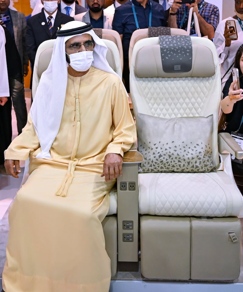 Sheikh Mohammed sits in a plane seat on display at the Arabian Travel Market.