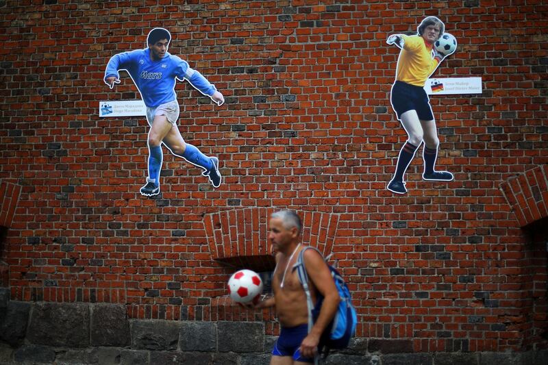 A man walks past posters of soccer players in Kaliningrad, Russia, June 17, 2018. Ivan Alvarado / Reuters