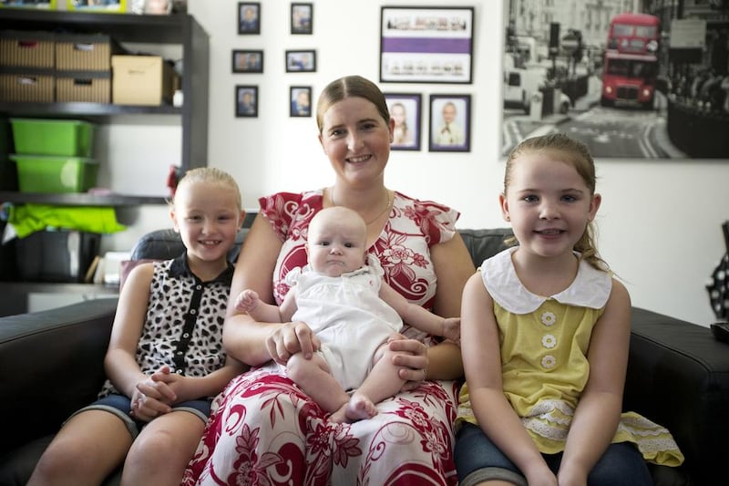 Stacey Turnbull with her daughters Amelie, 8, left, Imogen, 14 weeks, and Isla, 5. The British mother who lives in Abu Dhabi’s Al Reef Villas area says she took her child to the cinema when she was only a few weeks old. Christopher Pike / The National
