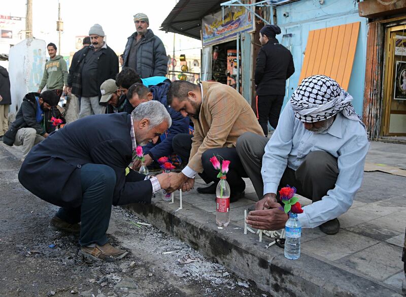 People light candles at the site of Monday's twin suicide bombings in Baghdad, Iraq, Tuesday, Jan. 16, 2018. Two suicide bombers blew themselves up at a busy street market in central Baghdad on Monday, in back-to-back explosions that killed dozens and wounded many civilians, Iraqi health and police officials said. It was the deadliest attack since last month's declaration of victory over the Islamic State group. (AP Photo/Karim Kadim)