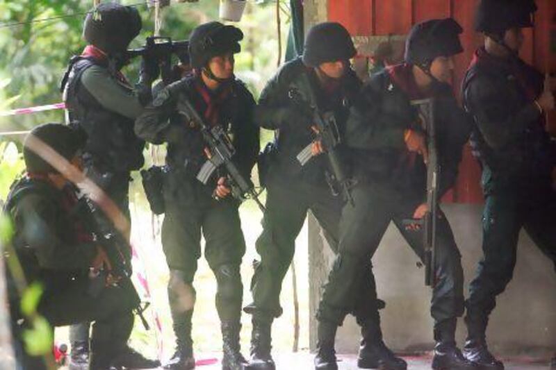 Police stand guard during a suspected attack by insurgents at a military base in southern Thailand.