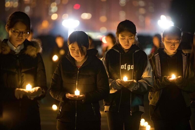 Students holding candles at Nanjing Normal University during a memorial ceremony ahead of China's National Memorial Day for Nanjing massacre victims in Nanjing city. AFP Photo