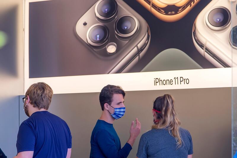 epa08420303 An employee assists a customer inside a reopened Apple Store at The Summit shopping center in Birmingham, Alabama, USA, 13 May 2020. A handful of Apple's US retail stores are being reopened with strict social distancing guidelines for customers amid the coronavirus COVID-19 pandemic. The spread and containment efforts of the coronavirus COVID-19 pandemic has caused disruptions to daily life across the globe.  EPA/ERIK S. LESSER