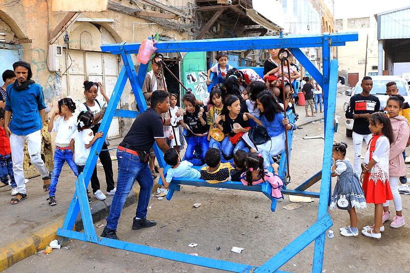 Yemeni children sit on a ride as people celebrate the Eid Al-Adha in Aden.  AFP