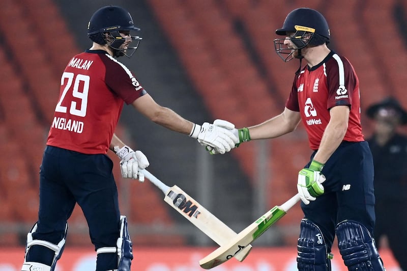 England's Jos Buttler, right, is congratulated by teammate Dawid Malan after reaching his half-century. AFP