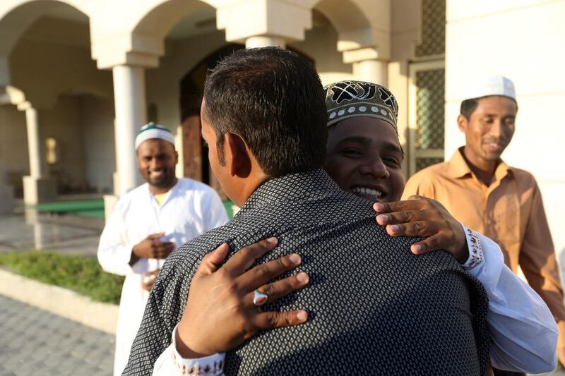 Abdul Alim (wearing white) and Hadayed Hussain greet each other at the Khalifia City Mosque after for the Eid Al Adha prayers in Abu Dhabi October. Sammy Dallal / The National