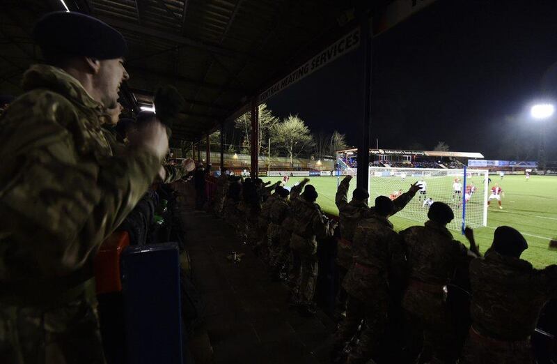 British Army personnel celebrate a goal as they watch the football match against the German Army on Wednesday to mark 100 years since the World War I Christmas Truce. The British Army won the match 1-0. Toby Melville / Reuters