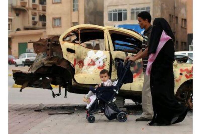 A Libyan family walks past a charred car in Benghazi. A reader who worked as a construction project manager in Benghazi and other Libyan cities expresses the hope that the current crisis will end favourably. Saeed Khan / AFP