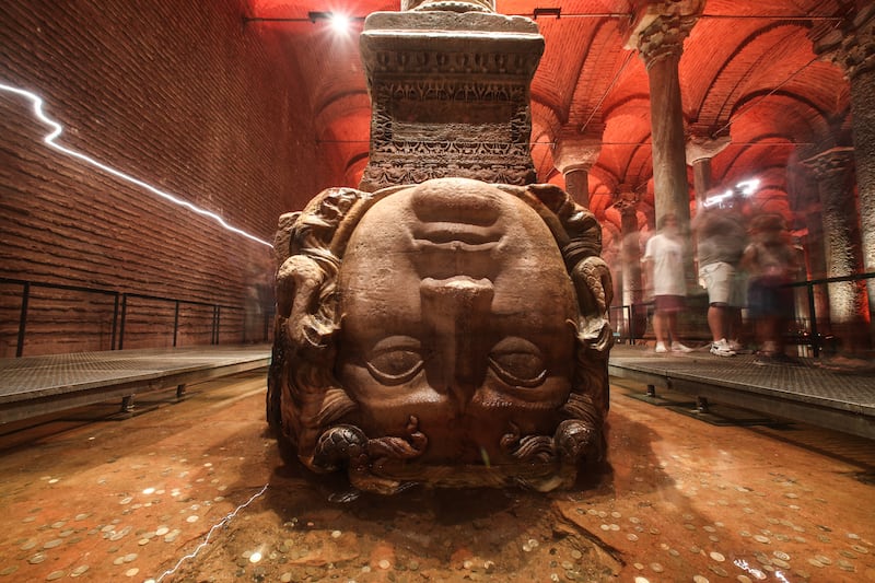 People walk behind the Medusa head in the Basilica Cistern in Istanbul, Turkey, 24 July 2022.  The site has been restored by the Istanbul Metropolitan Municipality and is now open for visitors again.  The Byzantine structure was commissioned by Emperor Justinian and built in 532.  The underground Basilica, also called Underground Cistern, is the largest well preserved cistern in Istanbul, which rests on a total of 336 columns.  According to historical texts, more than 7,000 slaves were involved in the construction of the cistern.   EPA / SEDAT SUNA