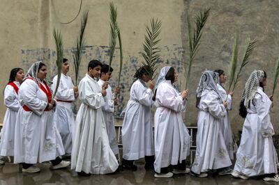 Deacons and deaconesses march with palm fronds in a procession during the Palm Sunday service at the Syriac Catholic Church of Mart Shmoni in Erbil, the capital of Iraq's Kurdish region, on Sunday. AFP