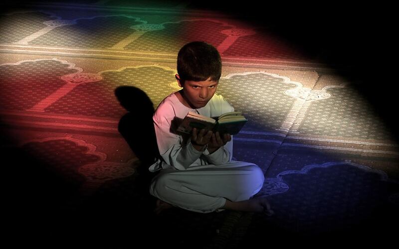 A Palestinian boy reads the Quran in the Al-Omari mosque during the Muslim holy month of Ramadan, in Gaza City, June 20, 2015. Most Muslims around the world have begun observing the holy fasting month of Ramadan. Mohammed Saber / EPA