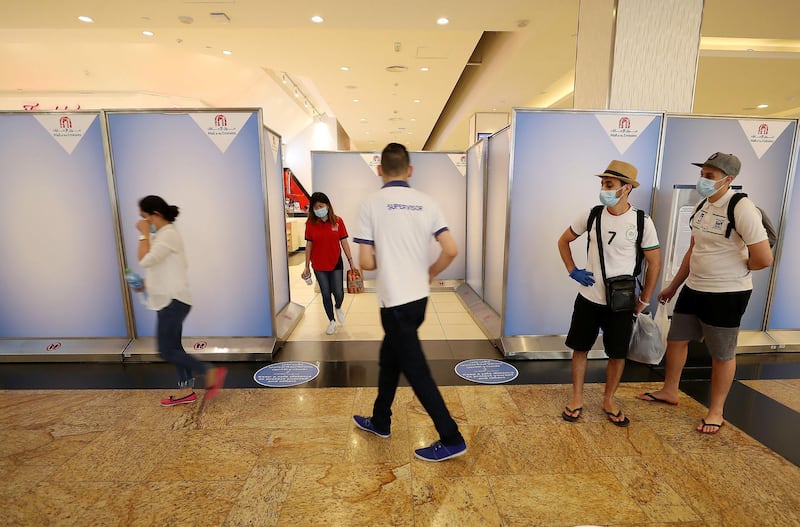 DUBAI, UNITED ARAB EMIRATES , April 29 – 2020 :- Shoppers wearing protective face mask to prevent the spread of the coronavirus at Mall of the Emirates in Dubai. Authorities ease the restriction for the residents in Dubai. At present mall opening timing is 12:00 pm to 10:00 pm. Carrefour timing is 9:00 am to 10:00 pm. Barricades put up around the food court area during the Ramadan. (Pawan Singh / The National) For News/Standalone/Online. Story by Patrick