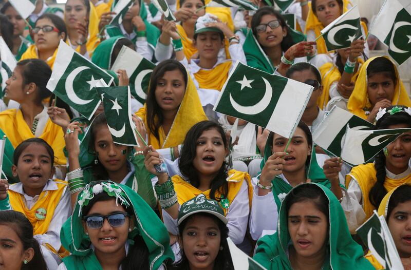 Attendees wave Pakistan's national flag while singing national songs at a ceremony to celebrate the country's 70th Independence Day at the mausoleum of Muhammad Ali Jinnah in Karachi, Pakistan August 14, 2017. REUTERS/Akhtar Soomro