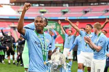epa09159143 Manchester City's Fernandinho (L) holds the trophy as his teammates celebrate after winning the Carabao Cup Final between Manchester City and Tottenham Hotspur at Wembley in London, Britain, 25 April 2021. EPA/ANDY RAIN EDITORIAL USE ONLY. No use with unauthorized audio, video, data, fixture lists, club/league logos or 'live' services. Online in-match use limited to 120 images, no video emulation. No use in betting, games or single club/league/player publications.