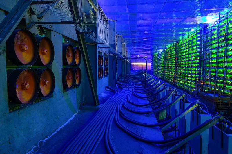 Industrial cooling fans operate to thermally regulate illuminated mining rigs at the CryptoUniverse cryptocurrency mining farm in Nadvoitsy, Russia, on Thursday, March 18, 2021. The rise of Bitcoin and other cryptocurrencies has prompted the greatest push yet among central banks to develop their own digital currencies. Photographer: Andrey Rudakov/Bloomberg