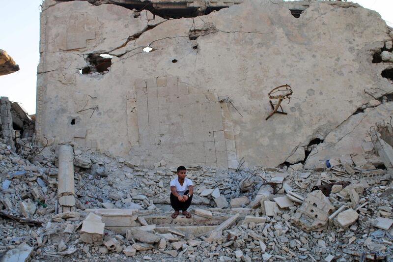 Moawiya Sayasina sits among the rubble in a rebel-held neighbourhood in the southern Syrian city of Daraa. Mohamad Abazeed / AFP