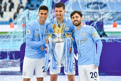 MANCHESTER, ENGLAND - MAY 23: Joao Cancelo, Ruben Dias and Bernardo Silva celebrates with the Premier League Trophy as Manchester City are presented with the Trophy as they win the league following the  Premier League match between Manchester City and Everton at Etihad Stadium on May 23, 2021 in Manchester, England. A limited number of fans will be allowed into Premier League stadiums as Coronavirus restrictions begin to ease in the UK. (Photo by Peter Powell - Pool/Getty Images)