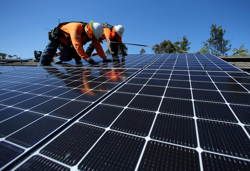 FILE PHOTO: Solar installers from Baker Electric place solar panels on the roof of a residential home in Scripps Ranch, San Diego, California, U.S. October 14, 2016.  Picture taken October 14, 2016.      REUTERS/Mike Blake/File Photo