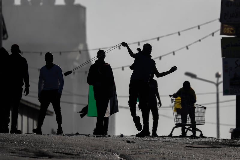Palestinian stone throwers clash with Israeli border police in A-Ram town, north of Jerusalem, on January 27, as Palestinians all over the West Bank protested to condemn the killing of nine Palestinians in Jenin refugee camp during an Israeli raid on January 26. EPA