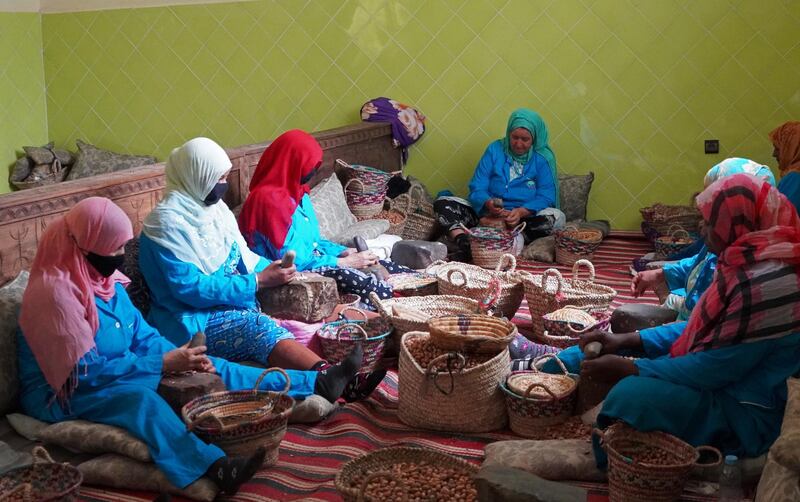 Amazigh women sit together as they crush argan nuts to extract the kernels, at Women's Agricultural Cooperative Taitmatine, in Tiout, near Taroudant, Morocco June 10, 2021. Picture taken June 10, 2021. REUTERS/Abdelhak Balhaki