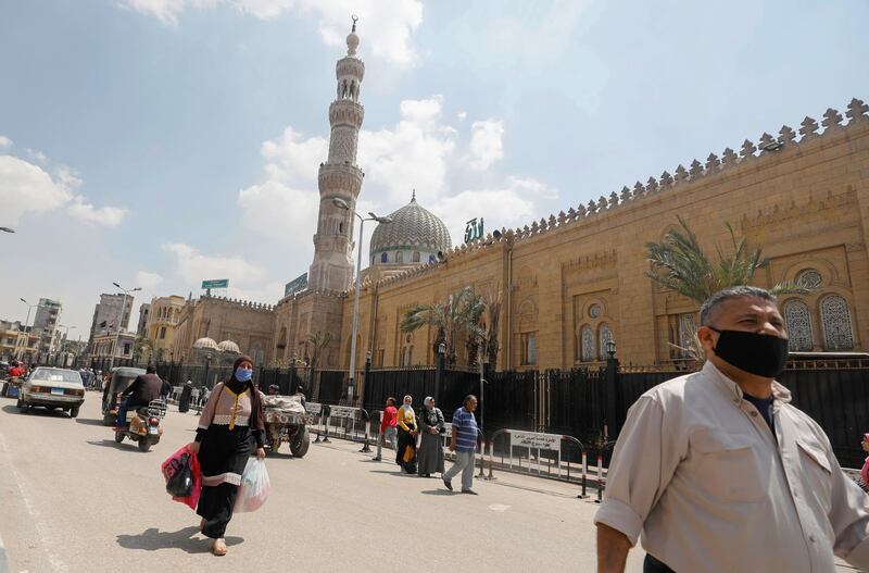 People wear protective face masks in front of the closed El Sayeda Zainab Mosque near markets that sell traditional Ramadan lanterns, in Cairo, Egypt. Reuters