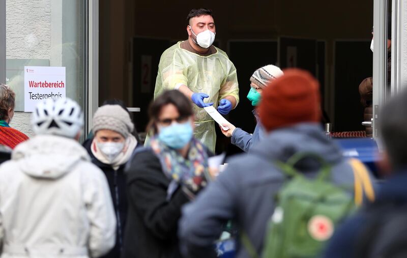 People receive their day pass to visit shops and cultural institutions after getting a negative Covid-19 rapid test result in Tuebingen, Germany. Reuters