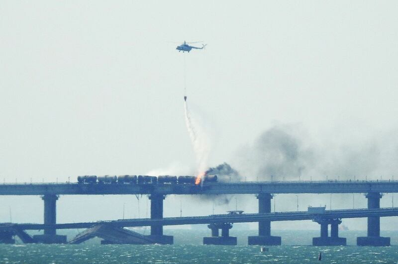 A firefigter helicopter pours water on train carriages. AFP